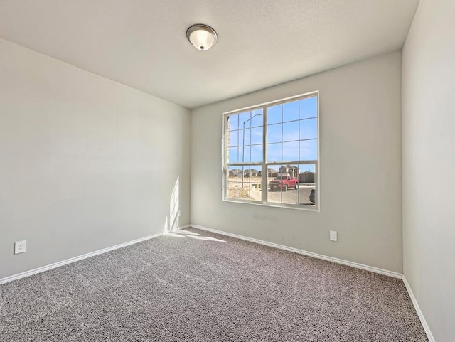 unfurnished room featuring baseboards and carpet flooring