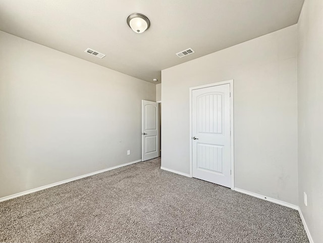 empty room with visible vents, carpet floors, and baseboards