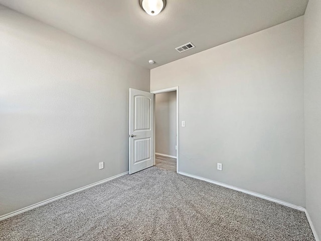 carpeted empty room with visible vents and baseboards