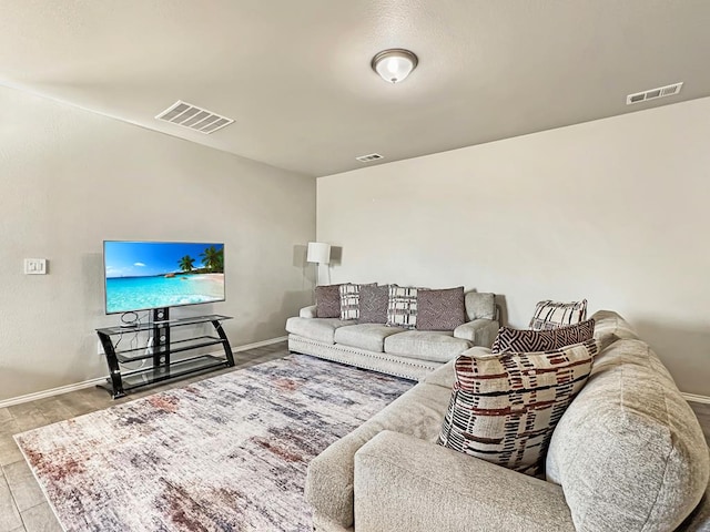 living room featuring visible vents, baseboards, and wood finished floors