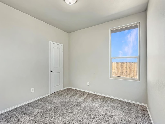 empty room featuring baseboards and carpet floors