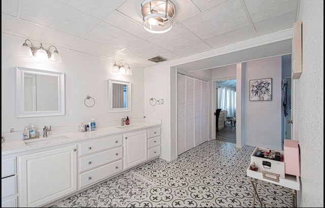 bathroom with a paneled ceiling and vanity