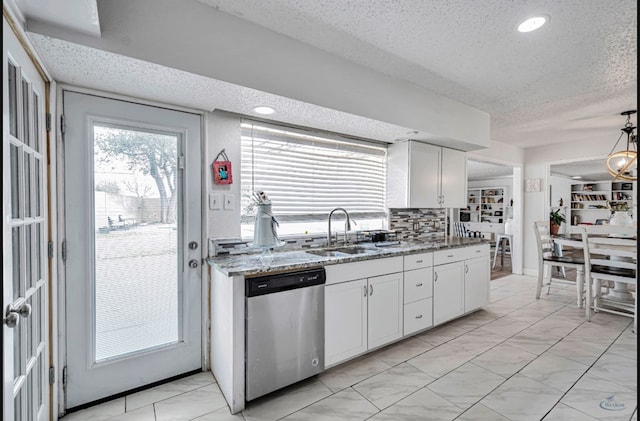 kitchen featuring sink, white cabinetry, dishwasher, stone counters, and backsplash