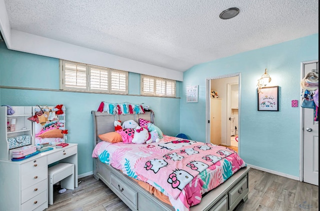 bedroom with light hardwood / wood-style floors and a textured ceiling