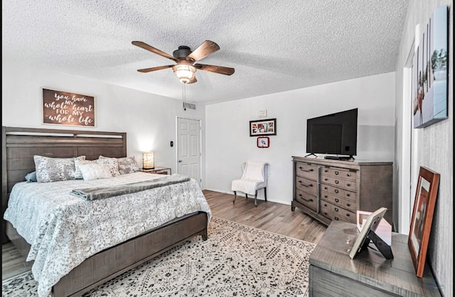 bedroom featuring a textured ceiling, ceiling fan, and hardwood / wood-style flooring