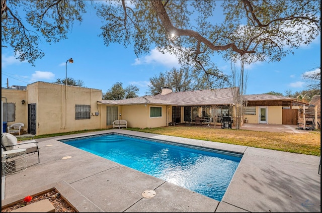 view of pool featuring a patio and a lawn