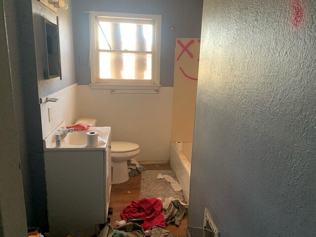 bathroom featuring vanity, visible vents, walk in shower, toilet, and a washtub