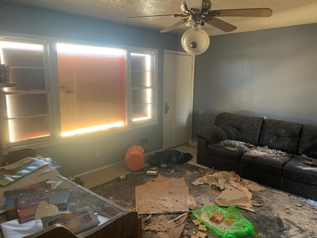 living area with a ceiling fan and a textured ceiling