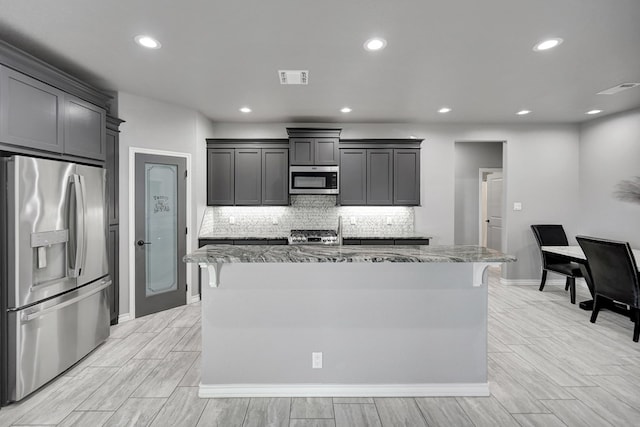 kitchen with light stone counters, visible vents, recessed lighting, stainless steel appliances, and tasteful backsplash