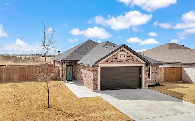 view of front of home featuring brick siding, fence, concrete driveway, a front yard, and an attached garage