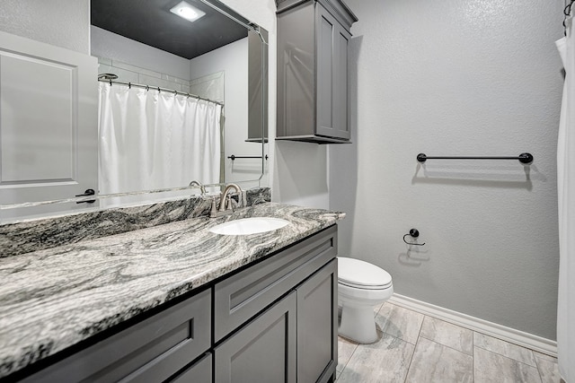 full bath featuring vanity, baseboards, wood tiled floor, toilet, and a textured wall