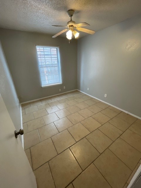 unfurnished room featuring light tile patterned flooring, ceiling fan, and a textured ceiling