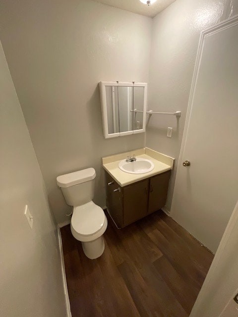 bathroom with vanity, toilet, and hardwood / wood-style floors