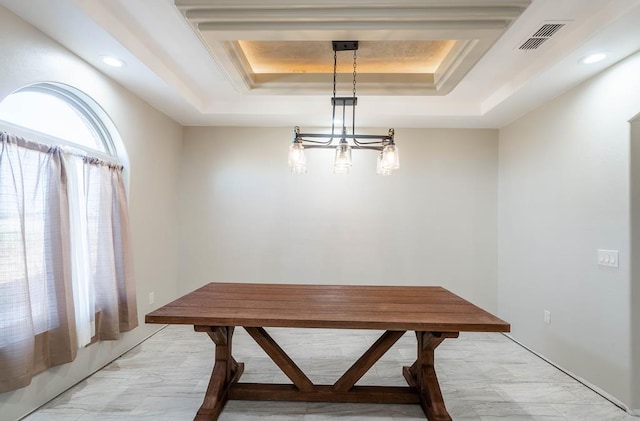 dining room with an inviting chandelier and a tray ceiling