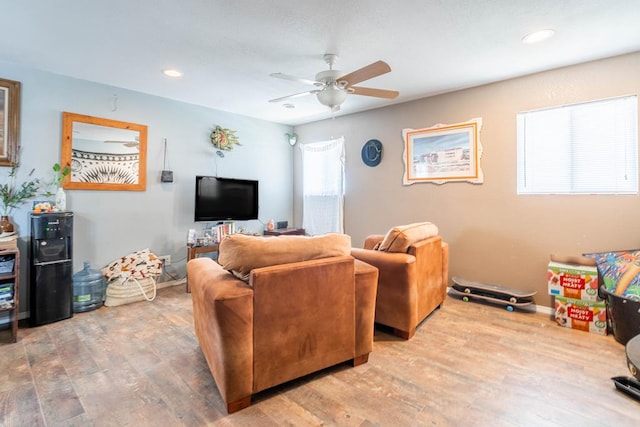 living room featuring ceiling fan and hardwood / wood-style flooring