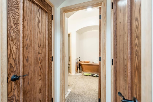 hall featuring carpet and vaulted ceiling