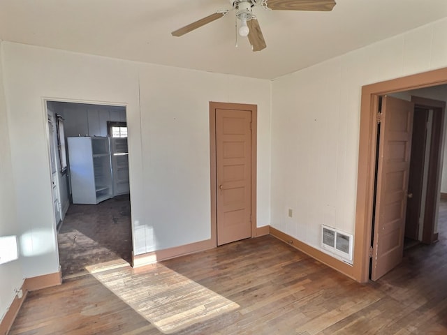 empty room with ceiling fan and dark hardwood / wood-style floors