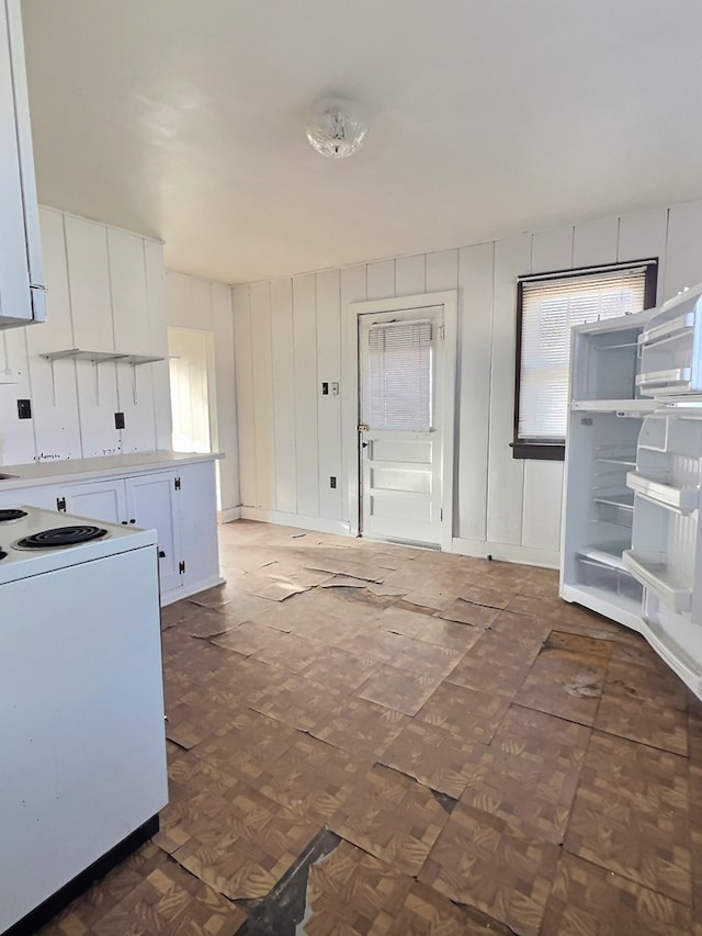 kitchen featuring white cabinets, electric stove, and dark parquet flooring