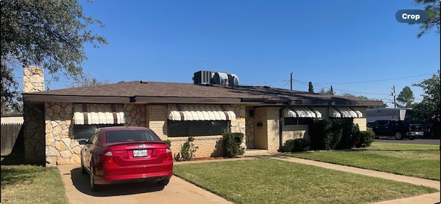 view of front of house featuring central AC and a front yard