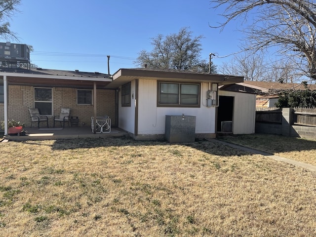 rear view of property with a lawn, central AC, and a patio area