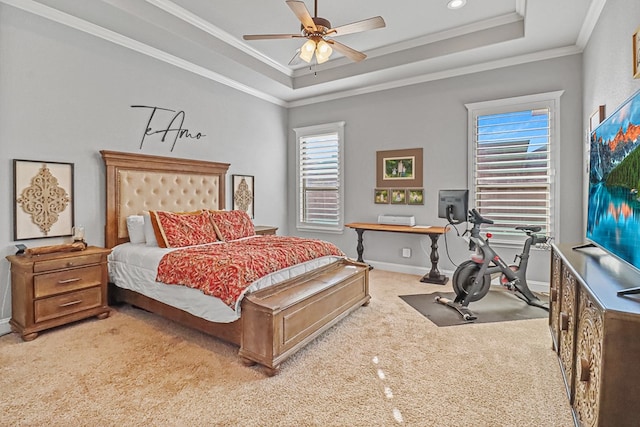 carpeted bedroom with crown molding, ceiling fan, a raised ceiling, and multiple windows