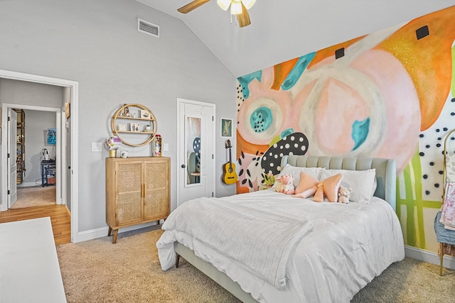 carpeted bedroom with ceiling fan and high vaulted ceiling