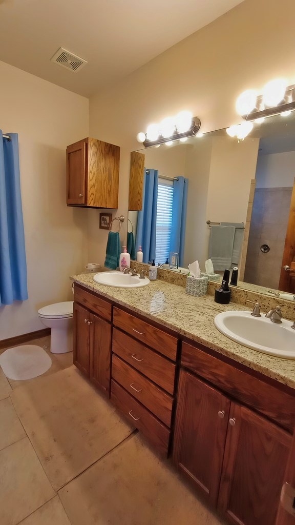 bathroom featuring tile patterned floors, vanity, and toilet