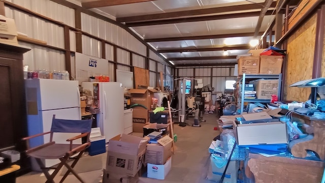 garage with white fridge and wooden walls