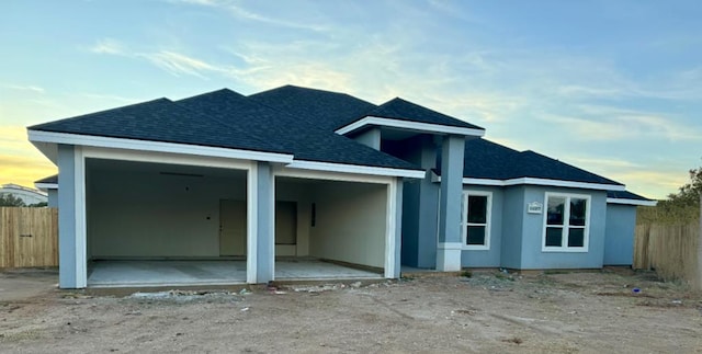 back house at dusk featuring a patio area