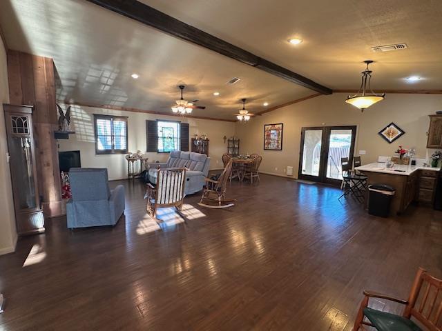 living room with lofted ceiling with beams, a wealth of natural light, visible vents, and dark wood-type flooring