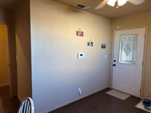 foyer with baseboards, visible vents, dark wood finished floors, and a ceiling fan