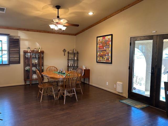 dining area with ornamental molding, dark wood-style flooring, vaulted ceiling, and baseboards