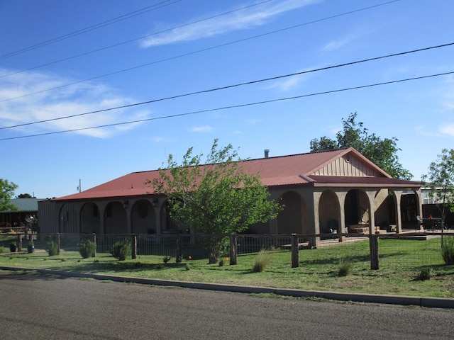 view of front facade with fence and metal roof