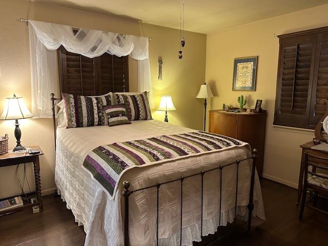 bedroom featuring dark wood finished floors and baseboards