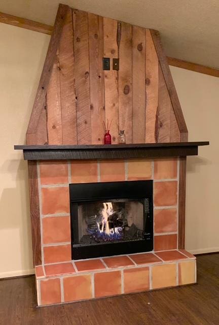 interior details featuring a fireplace, wood finished floors, and baseboards