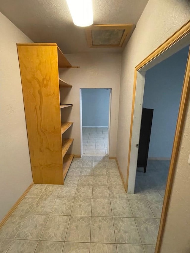 hallway with tile patterned floors and a textured ceiling