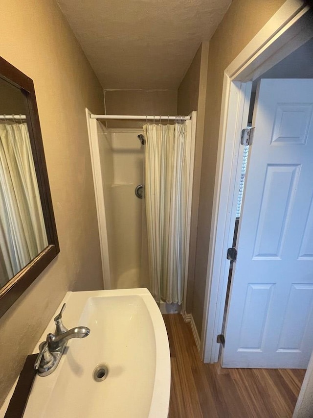 bathroom with a shower with shower curtain, sink, and hardwood / wood-style floors