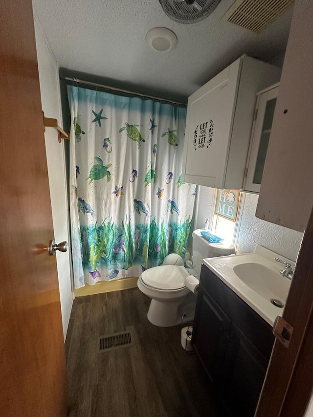 bathroom with toilet, vanity, a textured ceiling, and hardwood / wood-style flooring