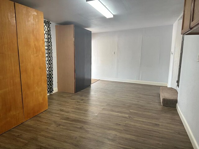 unfurnished room featuring dark wood-type flooring