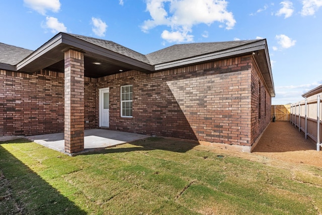 back of house with a yard and a patio