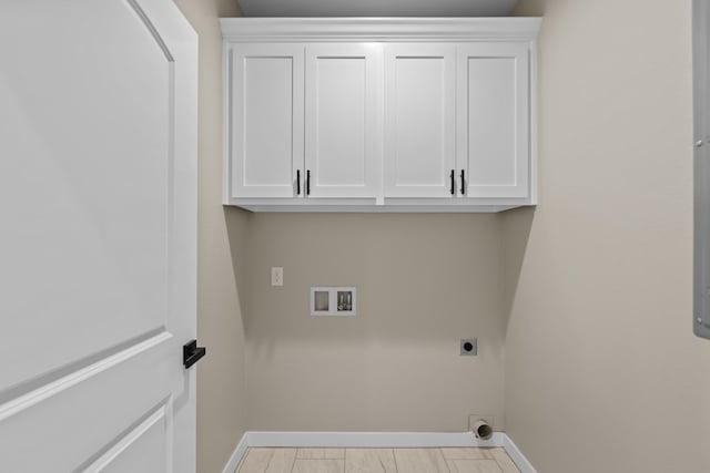 washroom with hookup for a washing machine, electric dryer hookup, and cabinets