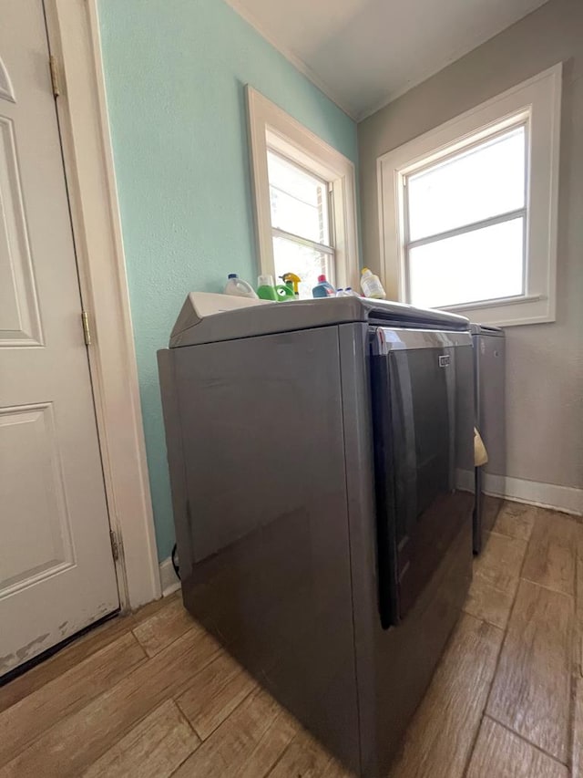 laundry room featuring washer and clothes dryer and light wood-type flooring