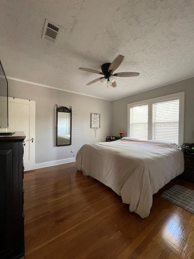 bedroom with a textured ceiling, ceiling fan, and dark wood-type flooring