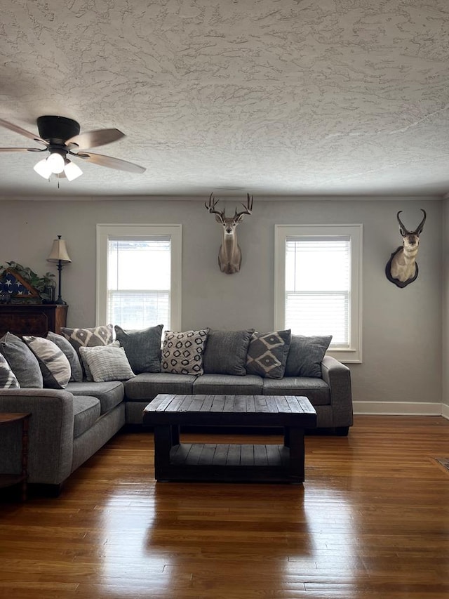 living room featuring dark wood-type flooring, a healthy amount of sunlight, and a textured ceiling