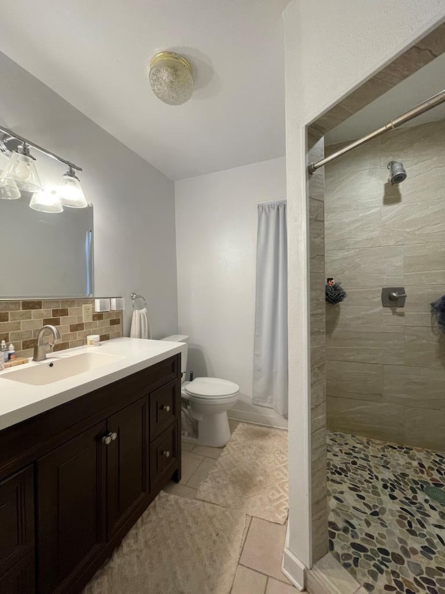 bathroom featuring a shower with shower curtain, tasteful backsplash, vanity, tile patterned flooring, and toilet