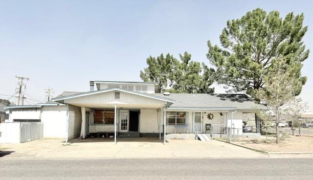 view of front facade featuring a carport and fence