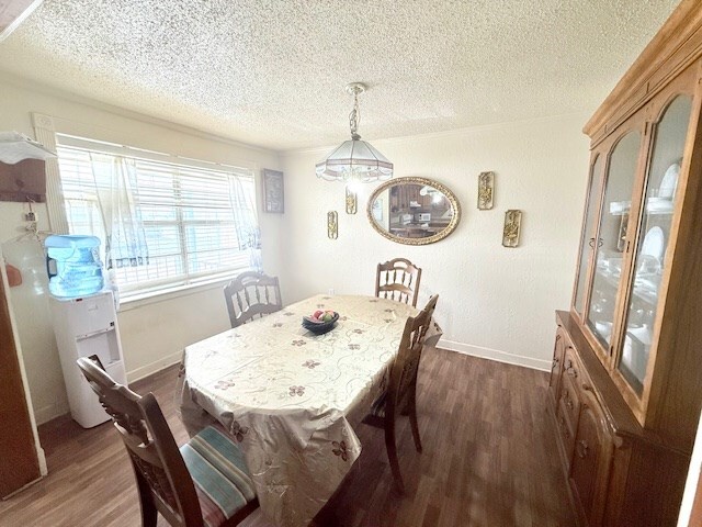 dining space with a textured ceiling, dark wood-type flooring, and baseboards