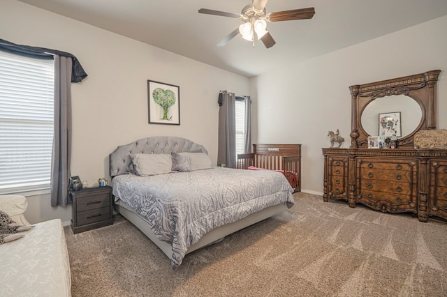 carpeted bedroom with multiple windows and a ceiling fan