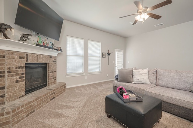 carpeted living area with a ceiling fan, a fireplace, visible vents, and baseboards