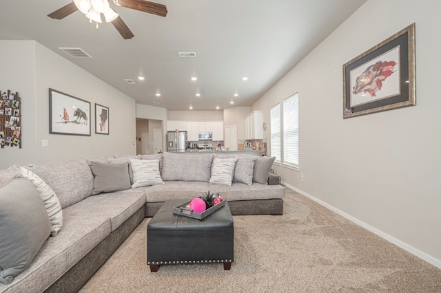 living area with recessed lighting, visible vents, light carpet, and baseboards